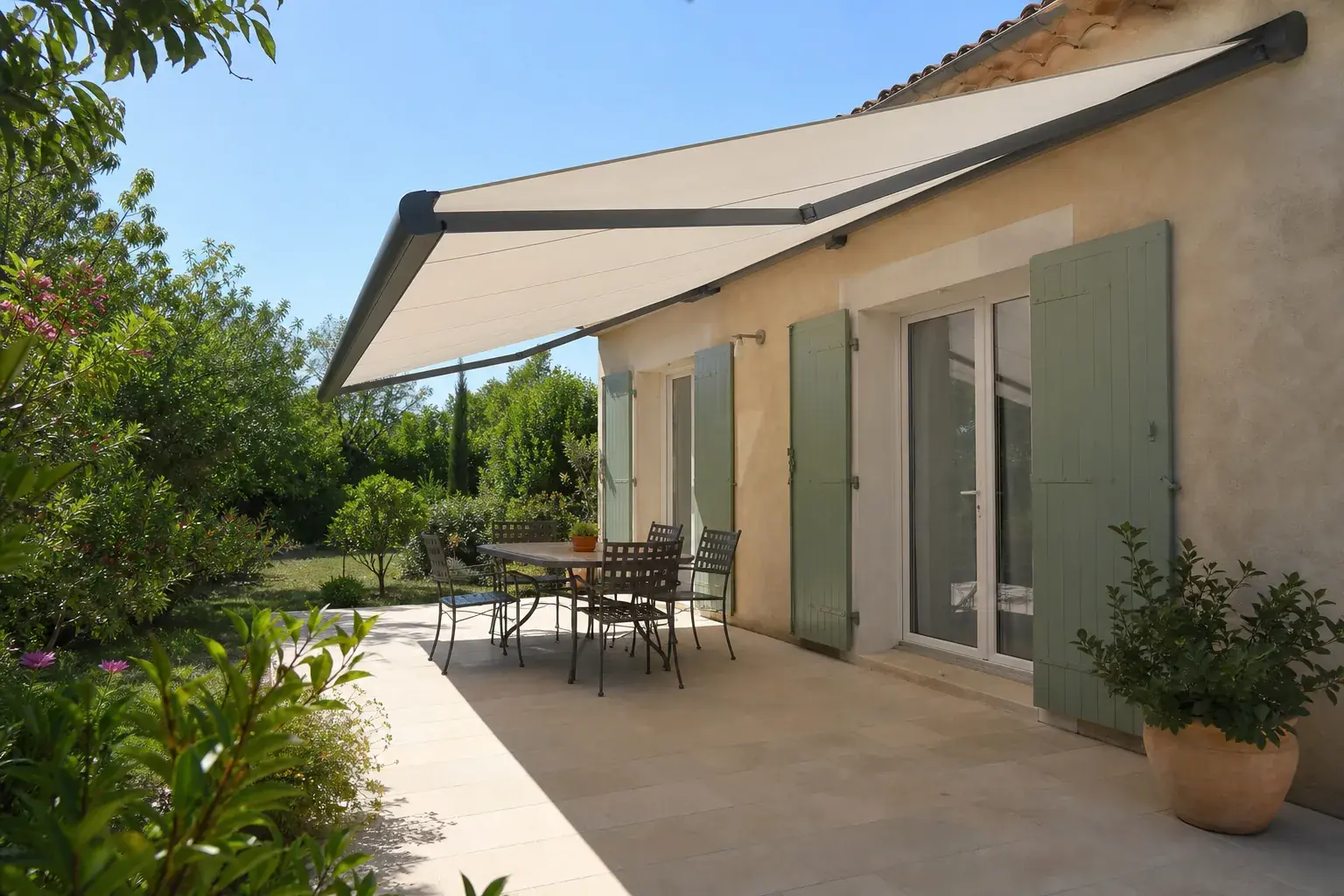 Store banne à toile claire déployé au-dessus d’une terrasse provençale, lumière d’été