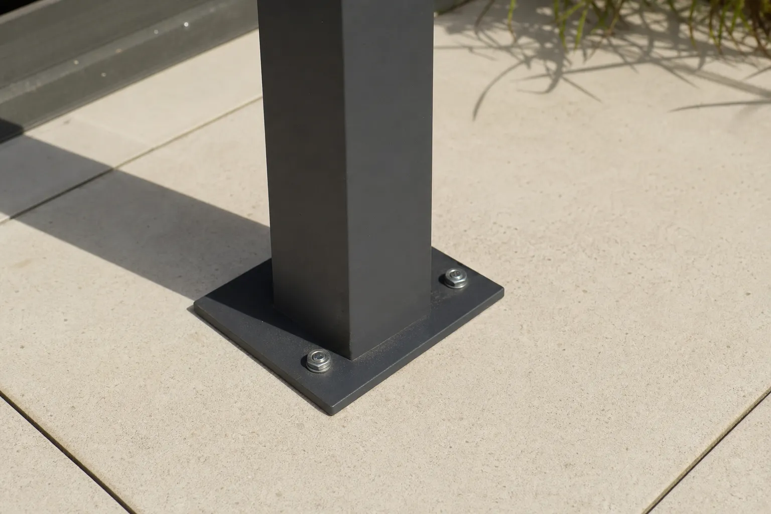 Détail d’un pied de pergola aluminium fixé sur une dalle de terrasse