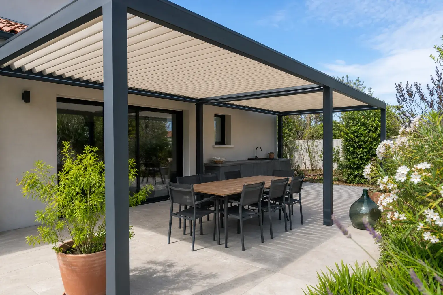 Terrasse ombragée par une pergola aluminium avec table et chaises, ambiance méditerranéenne